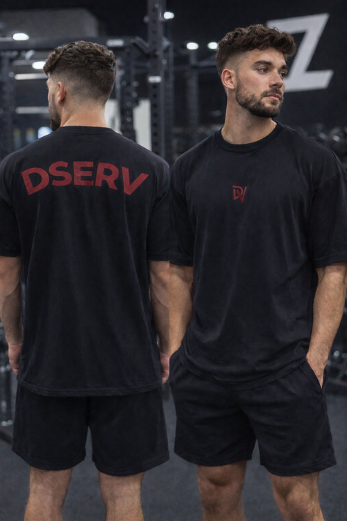 Two men wearing black t-shirts with red text in a gym setting