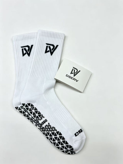 White crew socks with DV branding and black textured rubber soles for grip