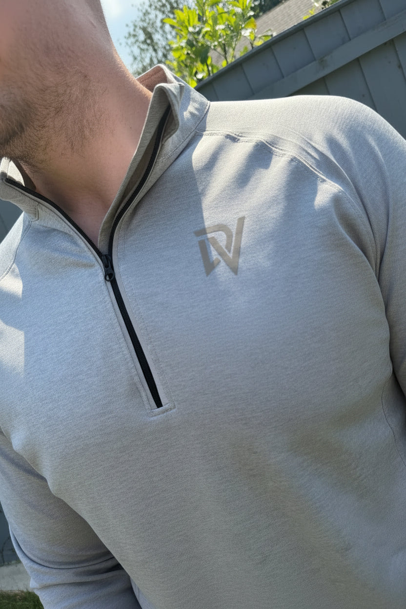A close up shot of a male wearing a fitted running quarter zip with the DV logo on the chest 